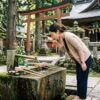 手水舎で口をすすぐ女性