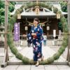 神社で茅の輪くぐりをする女性