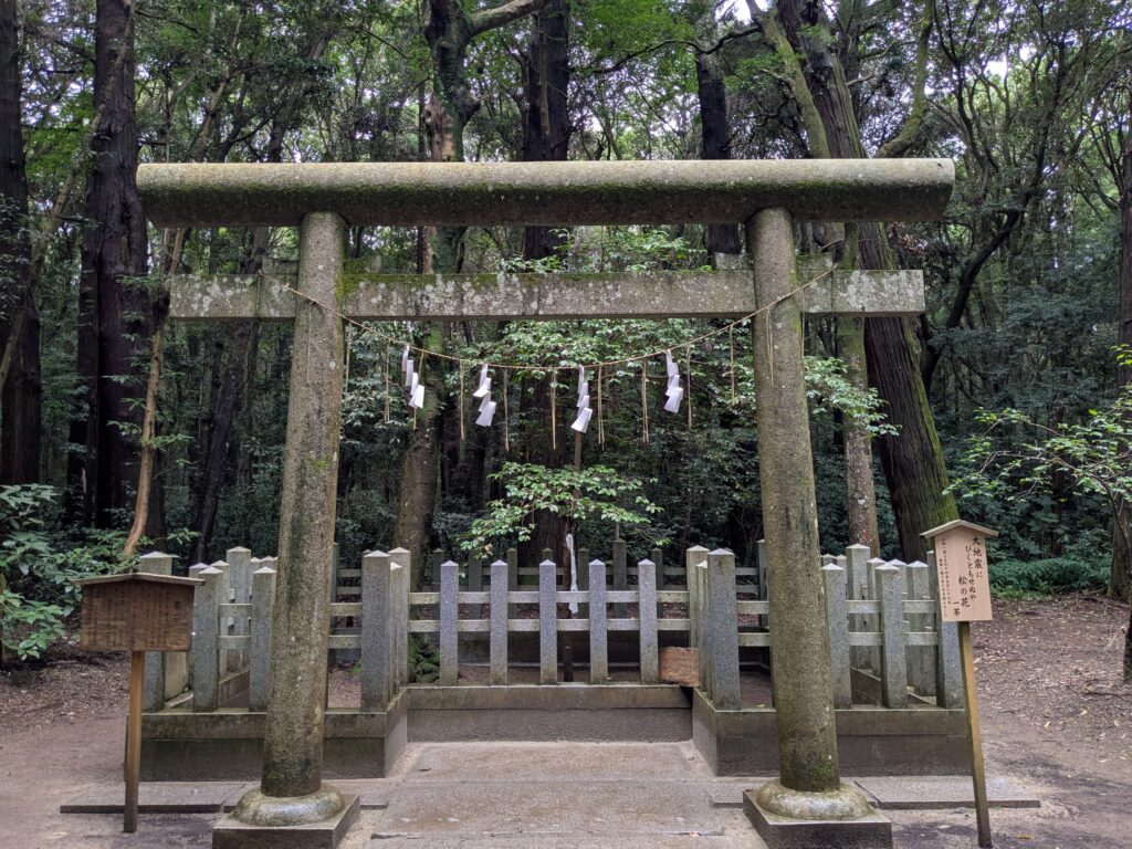 鹿島神宮の深い森に立つ石鳥居と石柵で囲まれた要石