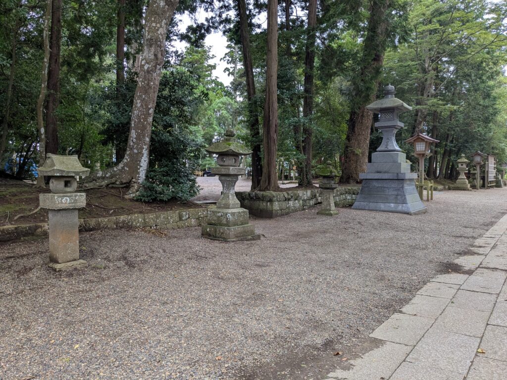 緑豊かな神社境内に大小の石灯籠が並ぶ風景