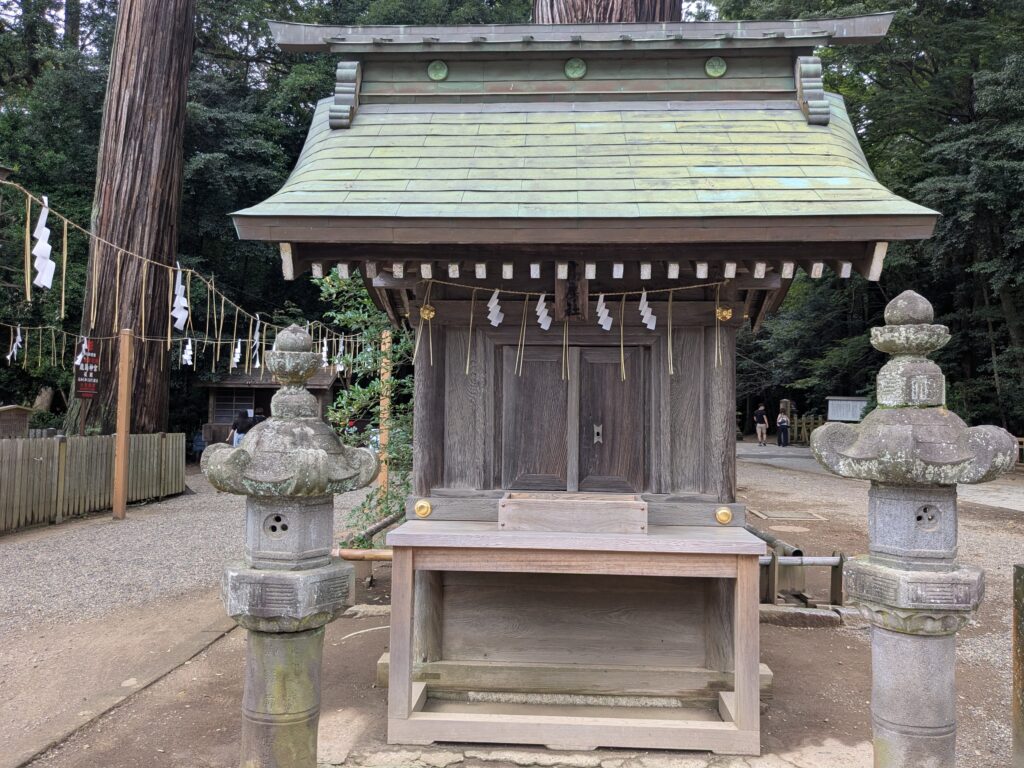 左右に石灯籠が立つ小さな木造の境内社